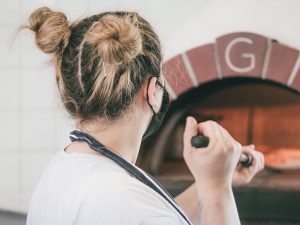 An image of a person making pizza